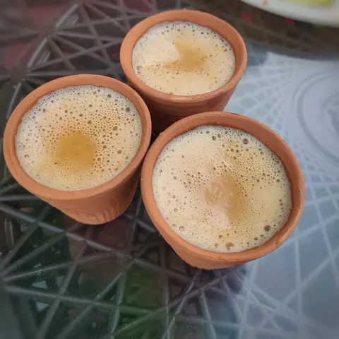 Three clay kulhads of frothy chai, seen from above (opens Instagram in a new tab)