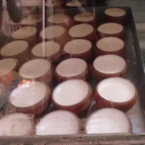 Rows of mishti doi set in clay pots (opens Instagram in a new tab)